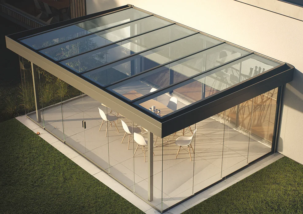 Pergola Diafano Lounge s bezrámovým posuvným zasklením a skleněnou střechou u domu – Moonex